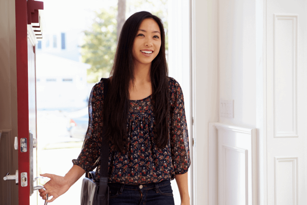 woman opening door of home