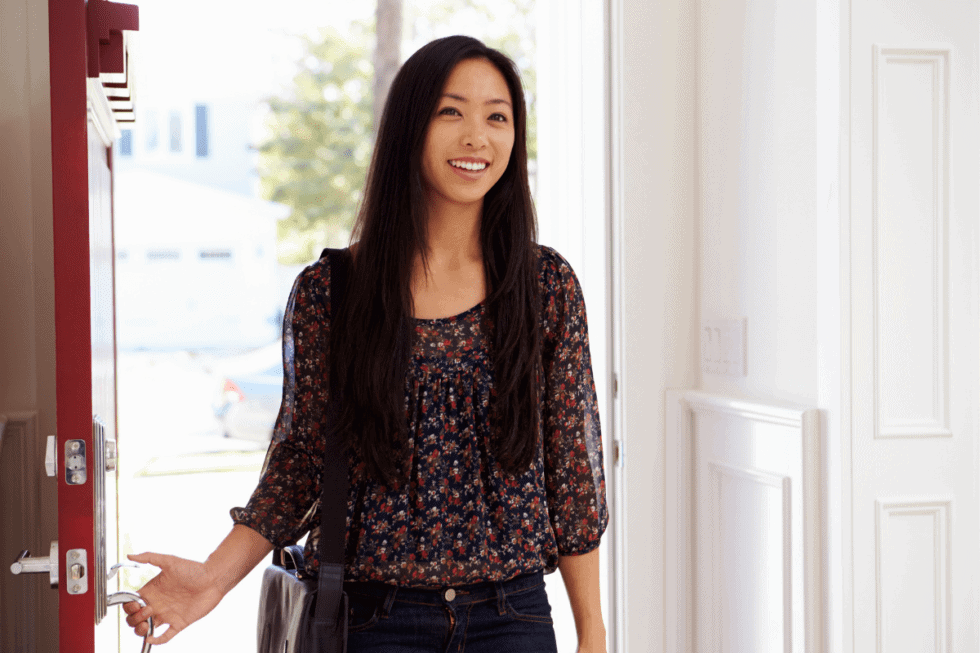 woman opening door of home