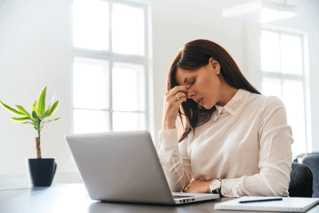 woman pinching bridge of nose headache