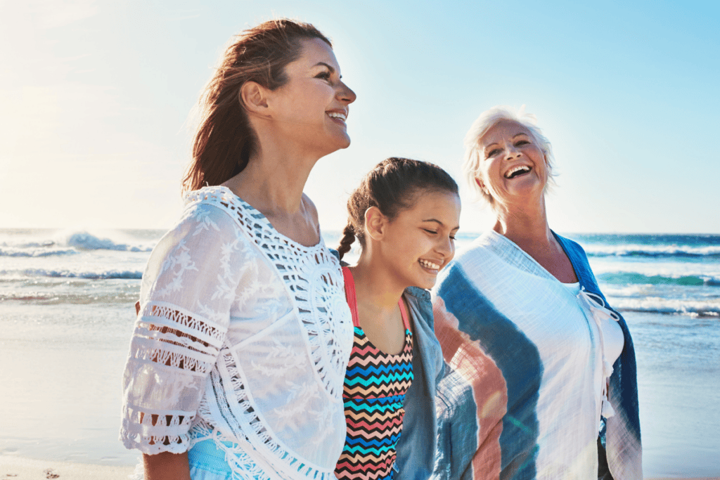 Three generations of women walking on beach