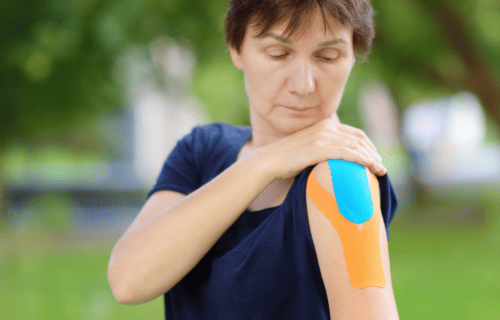 woman with Ehler's Danlos Syndrome taping shoulder