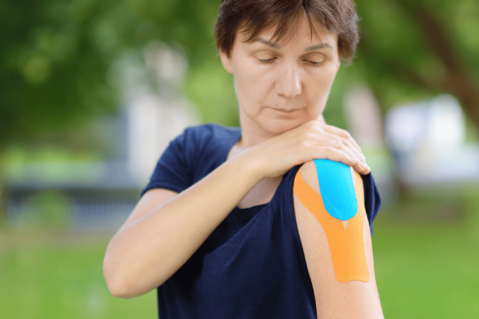 woman with Ehler's Danlos Syndrome taping shoulder